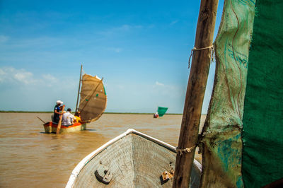 People in boat on lake against sky