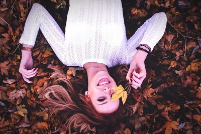 High angle view of woman lying down on autumn leaves