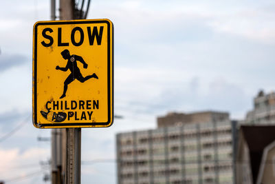 Close-up of road sign against sky