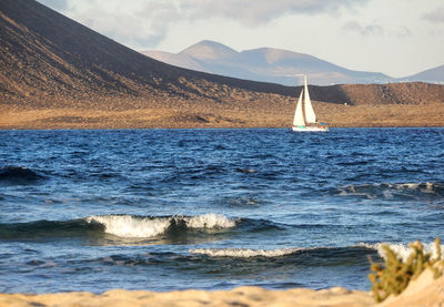 Sailboat in sea against sky