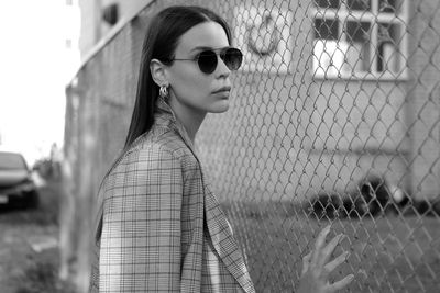 Portrait of young woman wearing sunglasses standing outdoors