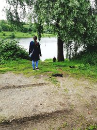 Rear view of woman walking on field