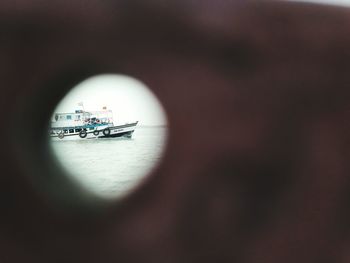 Reflection of people on boat in sea seen through window