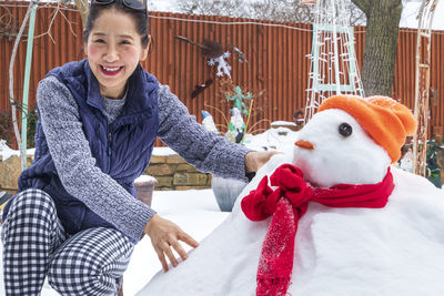 Portrait of smiling woman with snowman