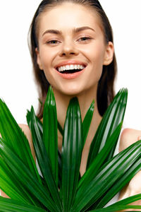 Portrait of smiling young woman against white background