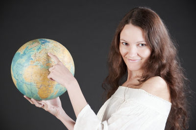 Portrait of a smiling young woman over black background