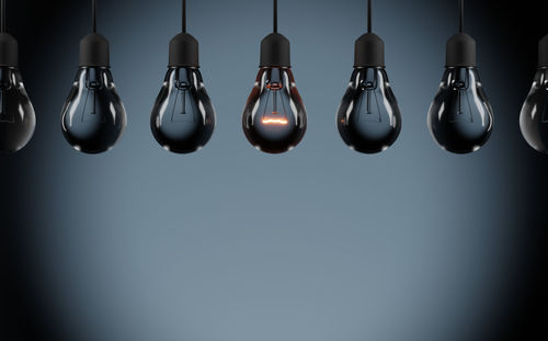 Close-up of light bulbs hanging against wall