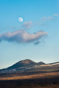 Scenic view of mountains against blue sky