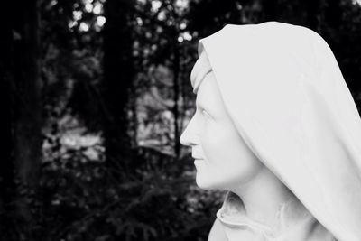 Close-up of young woman against trees