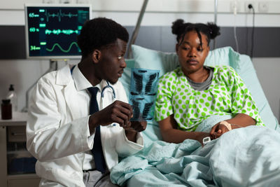 Portrait of doctor examining patient at home