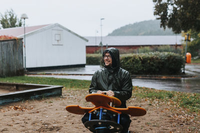 Happy man sitting on swing