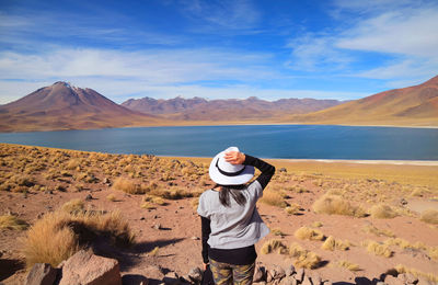 Female traveler being impressed with miscanti lake, amazing altiplanic lagoon in chile