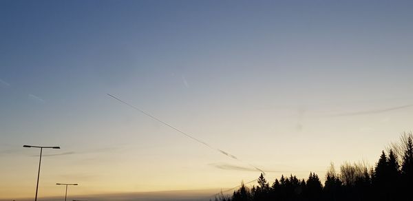 Low angle view of silhouette trees against sky at sunset