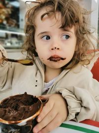 View of a cute girl eating chocolate ice cream