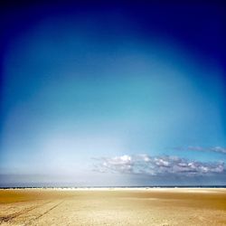 Scenic view of beach against clear blue sky