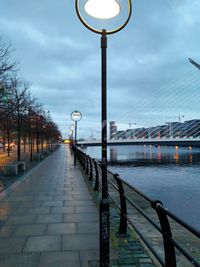 Street lights on bridge against sky