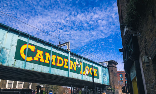 Low angle view of text on street against buildings in city