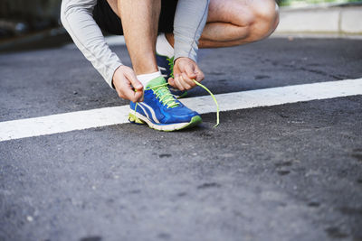 Low section of man standing on road