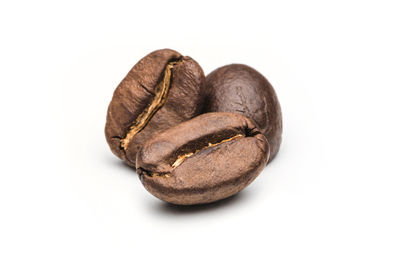 Close-up of roasted coffee beans against white background