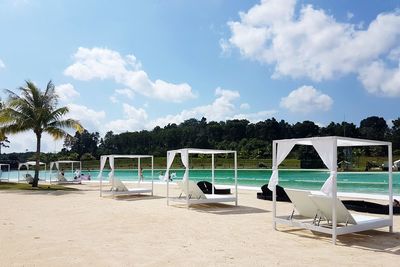 Chairs on beach against sky