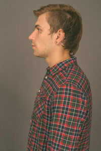 Side view of a young man against white background