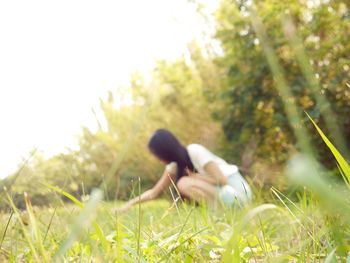 Rear view of woman sitting on grass