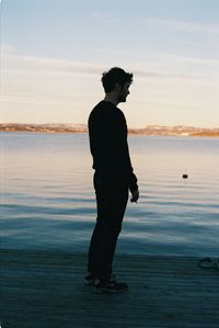 Rear view of woman standing on beach