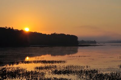 Scenic view of lake against sky during sunset