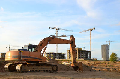 Cranes at construction site against sky