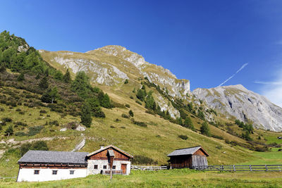 Houses on mountain against clear blue sky