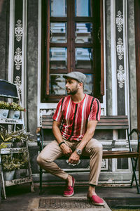 Full length of young man sitting on seat