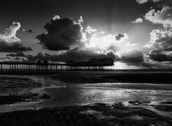 Scenic view of beach against cloudy sky