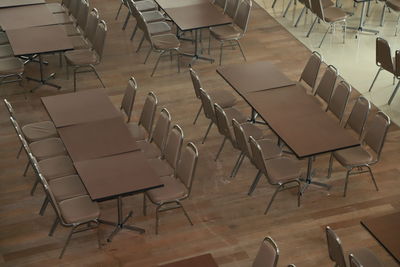 High angle view of empty chairs and tables arranged on hardwood floor