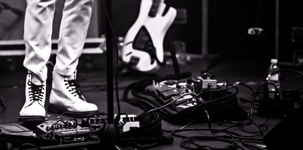 Low section of man sitting on guitar