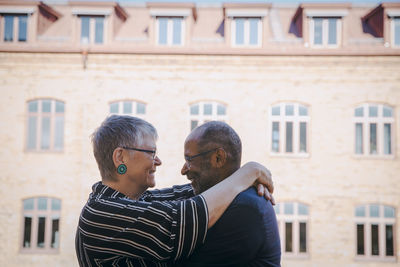 Smiling senior couple embracing each other in balcony