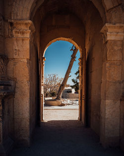 Old ruin building against clear sky seen through archway