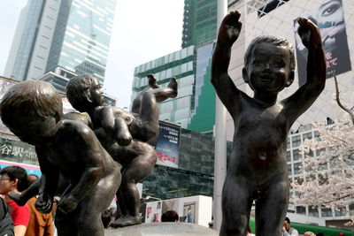 Low angle view of statue against buildings in city