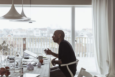 Man looking at camera while sitting on table