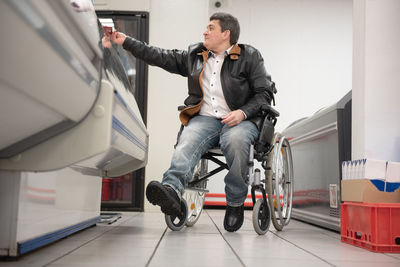 A disabled person in a wheelchair buys groceries