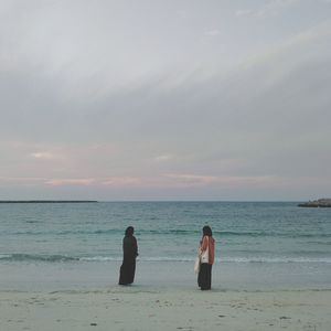 People on beach against sky