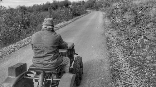 Rear view of man sitting on road