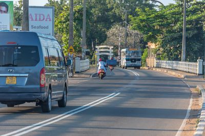 Man riding motorcycle on road in city