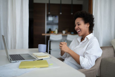 Happy mixed race businesswoman during online meeting