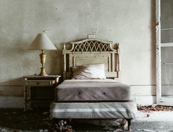 Rear view of man relaxing on bed against wall