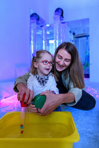 Child living with cerebral palsy interacting with her therapist during therapy session.