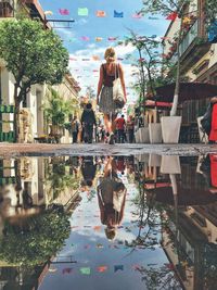 Low angle view of woman walking by puddle on street