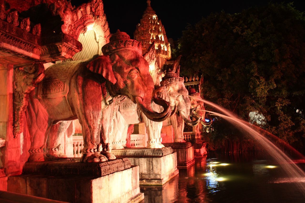 STATUE OF FOUNTAIN IN FRONT OF ILLUMINATED NIGHT