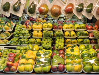 Various vegetables wrapped in plastic for sale at market stall