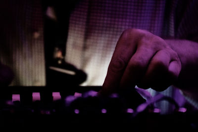 Close-up of human hand against purple wall