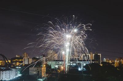 Firework display over illuminated buildings in city at night